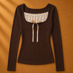 Brown long-sleeve top with lace neckline and bow on a brown background