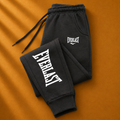 Black sweatpants with 'Everlast' logo on an orange background