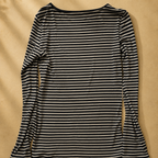 Black and white striped long-sleeve top on a beige background