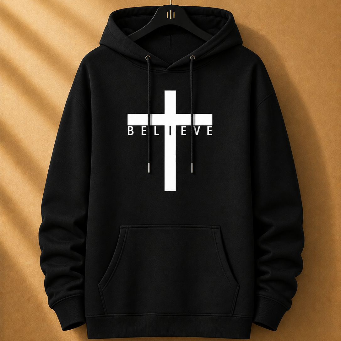 Black hoodie with a white cross and 'BELIEVE' text on a beige background