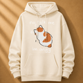 Beige hoodie with a cartoon cat and text on a brown background