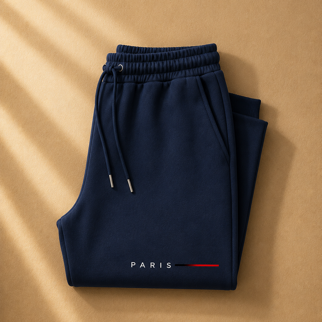 Folded navy blue pants with 'PARIS' text on a beige background